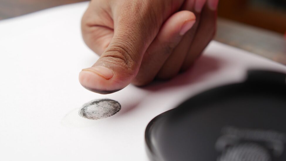 Ink fingerprint being taken for a SAPS police clearance application