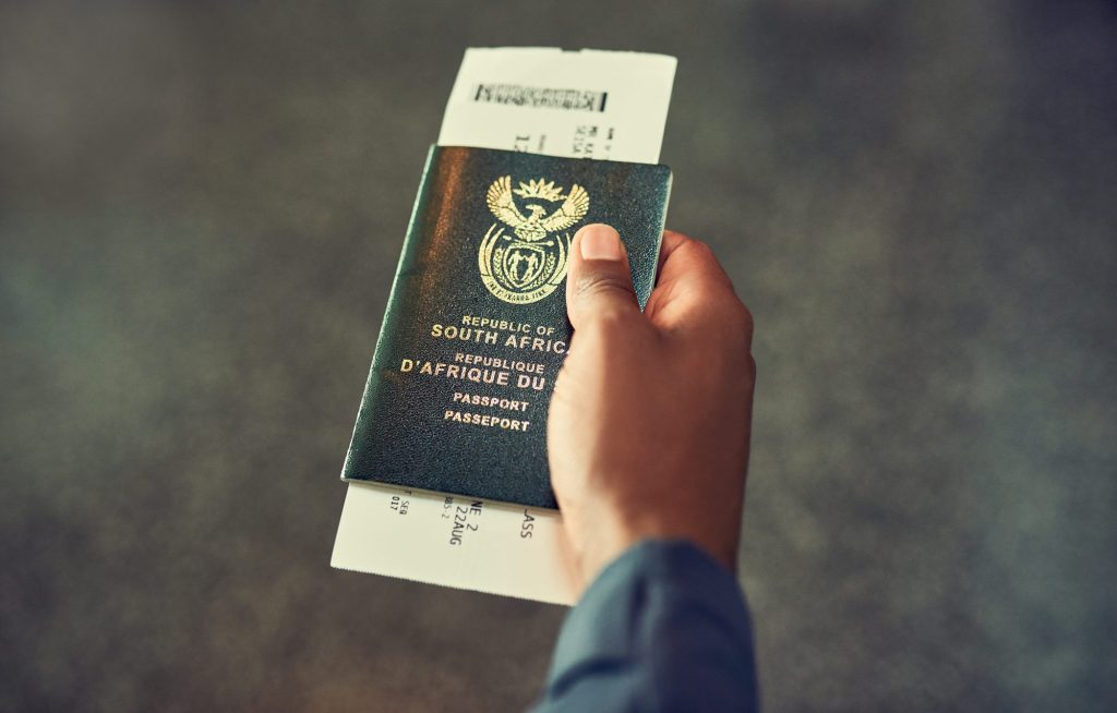 Traveller holding a passport in an airport lobby before a flight