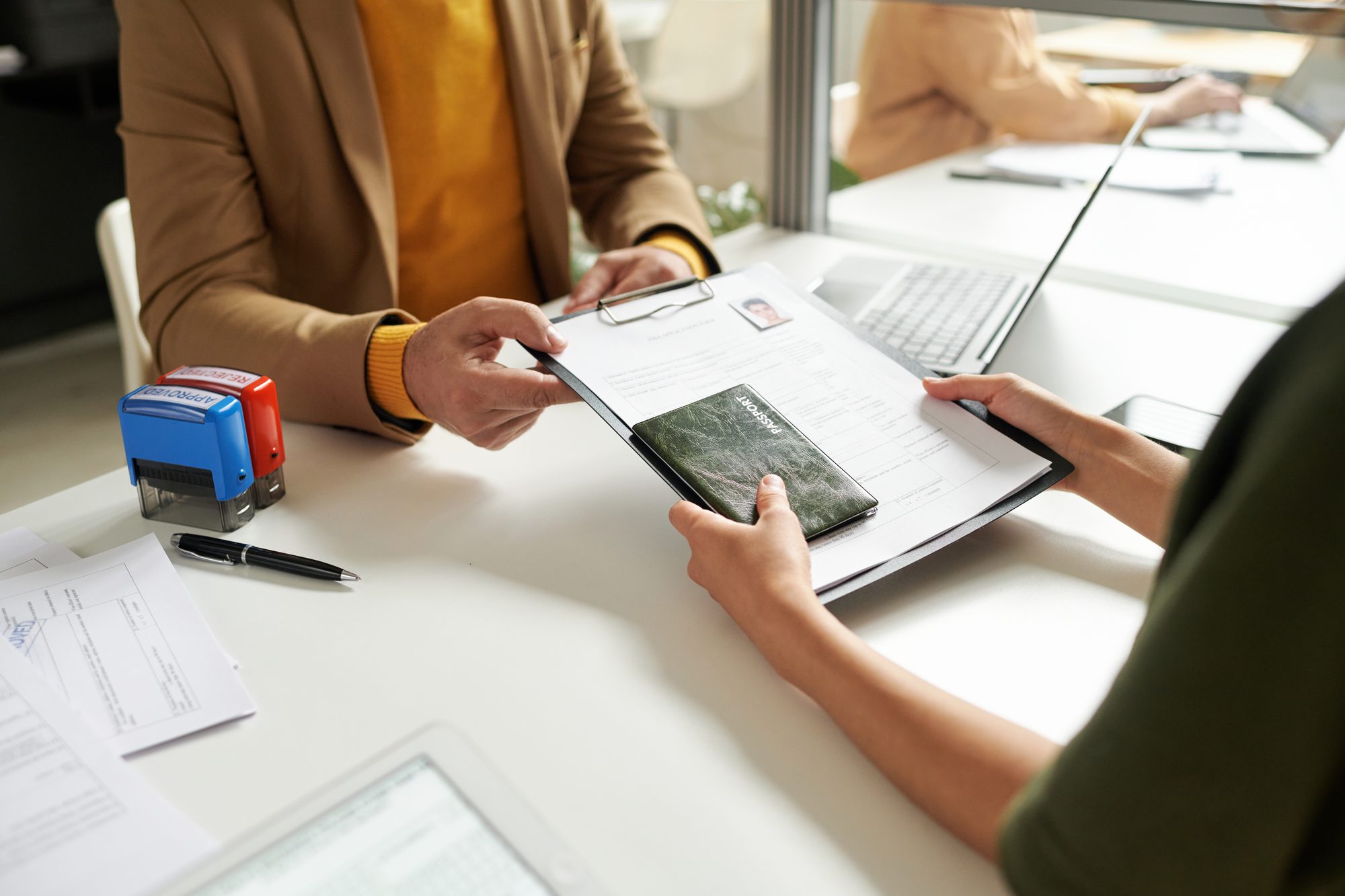 Visa consultant handing documents to an applicant