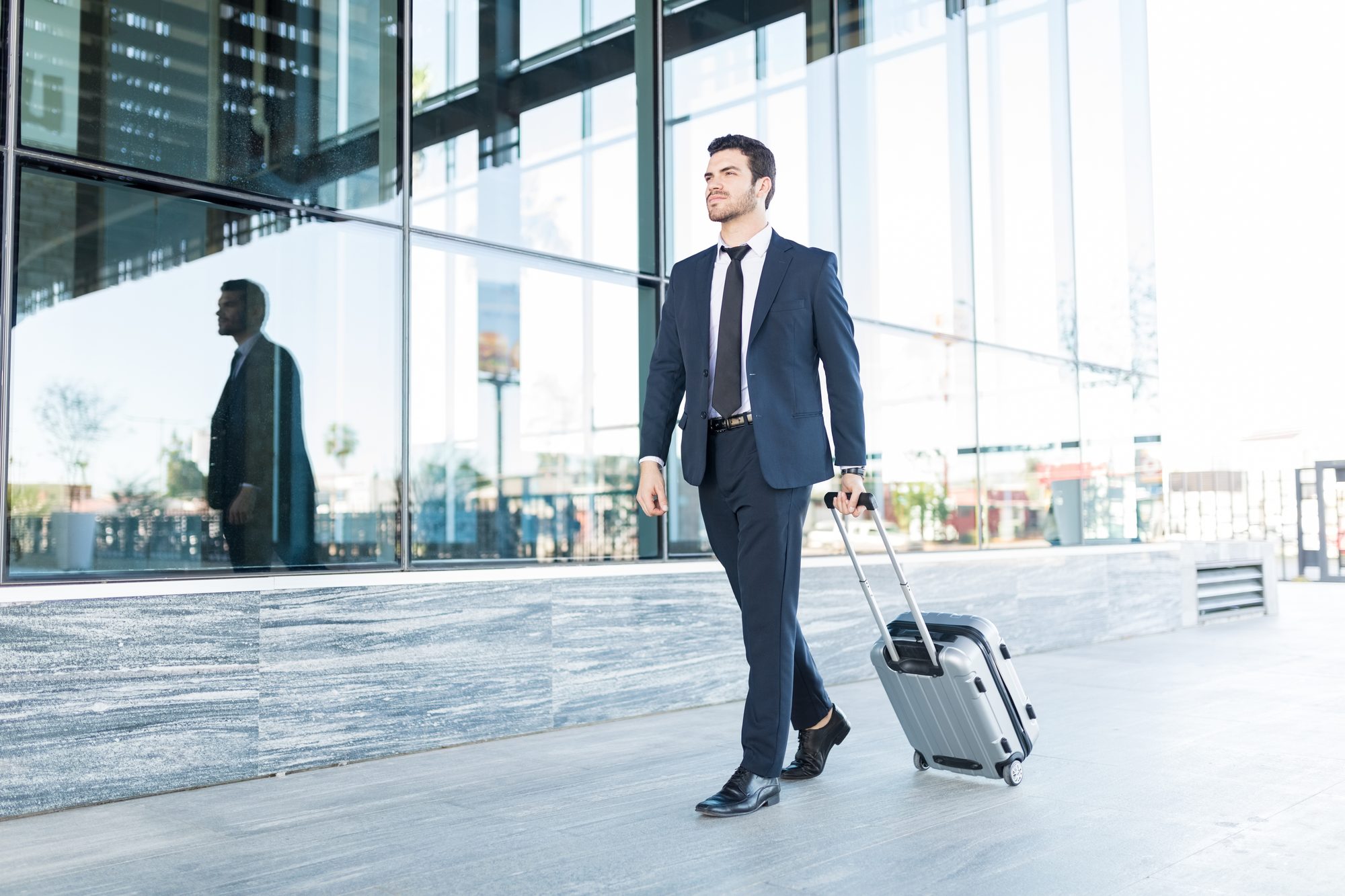 Professional traveller with a carry-on arriving in a UK business district