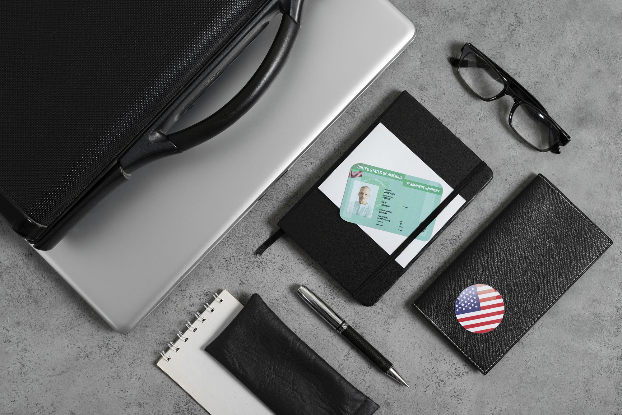 Passport, notebook and application papers arranged on a dark desk for a US trip