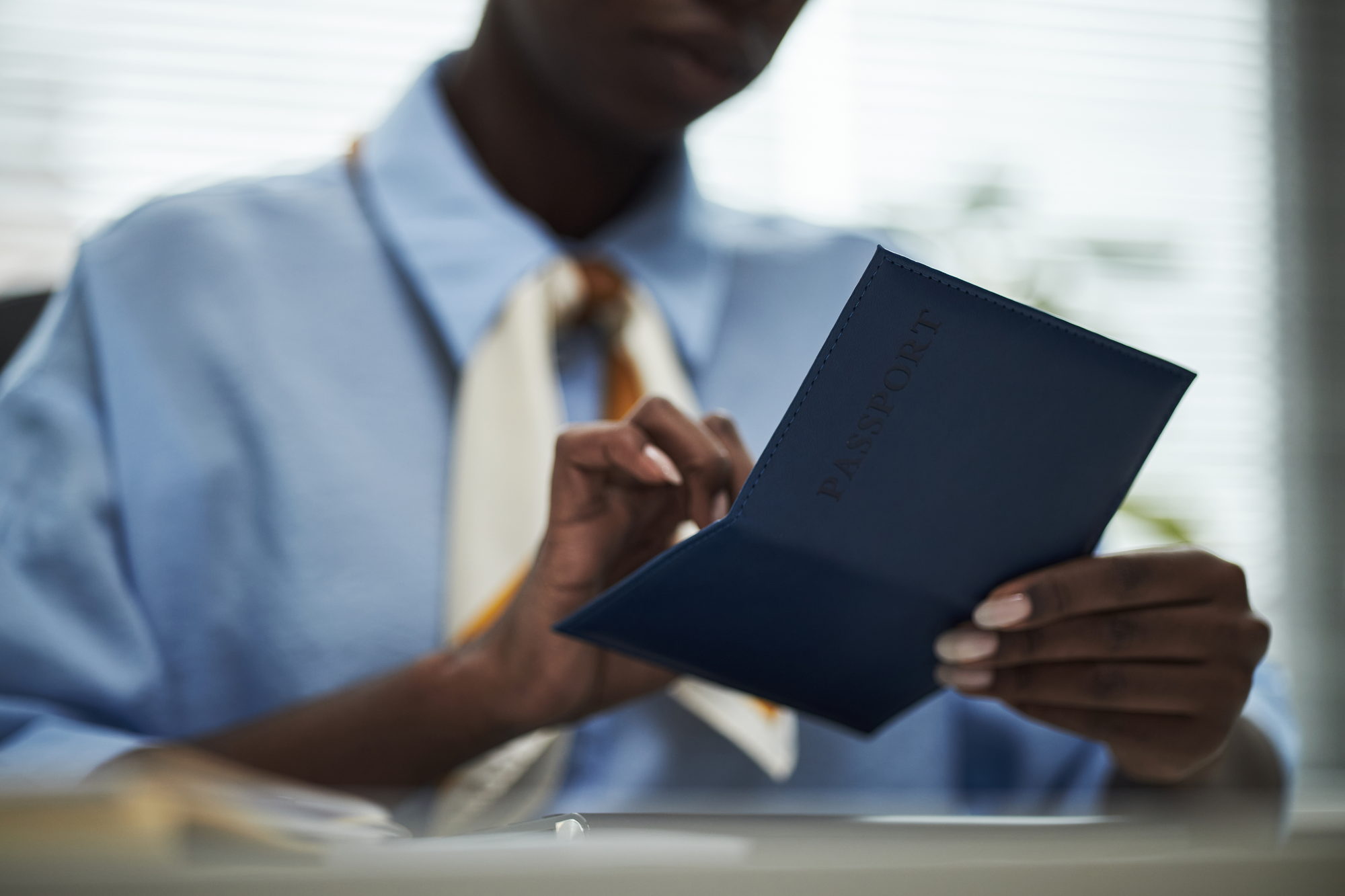 A person checking a passport before a police clearance application