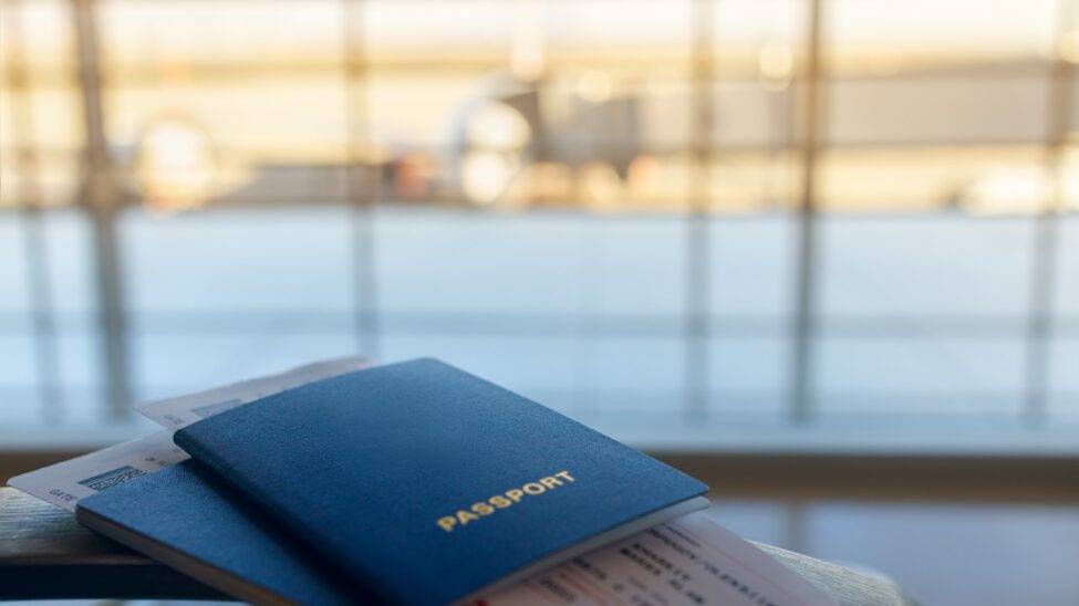 A passport and boarding pass at a departure gate before a flight to Dubai