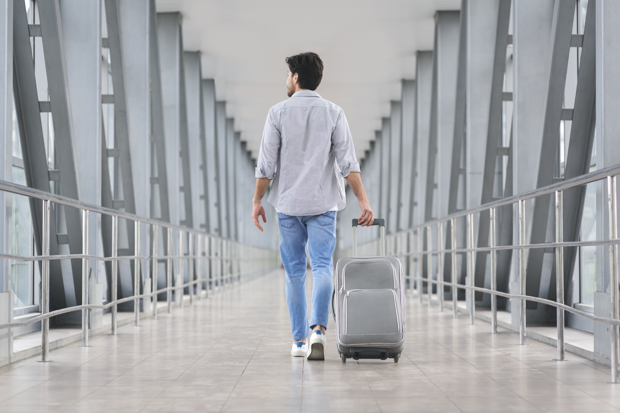 A traveller walking through a bright airport terminal