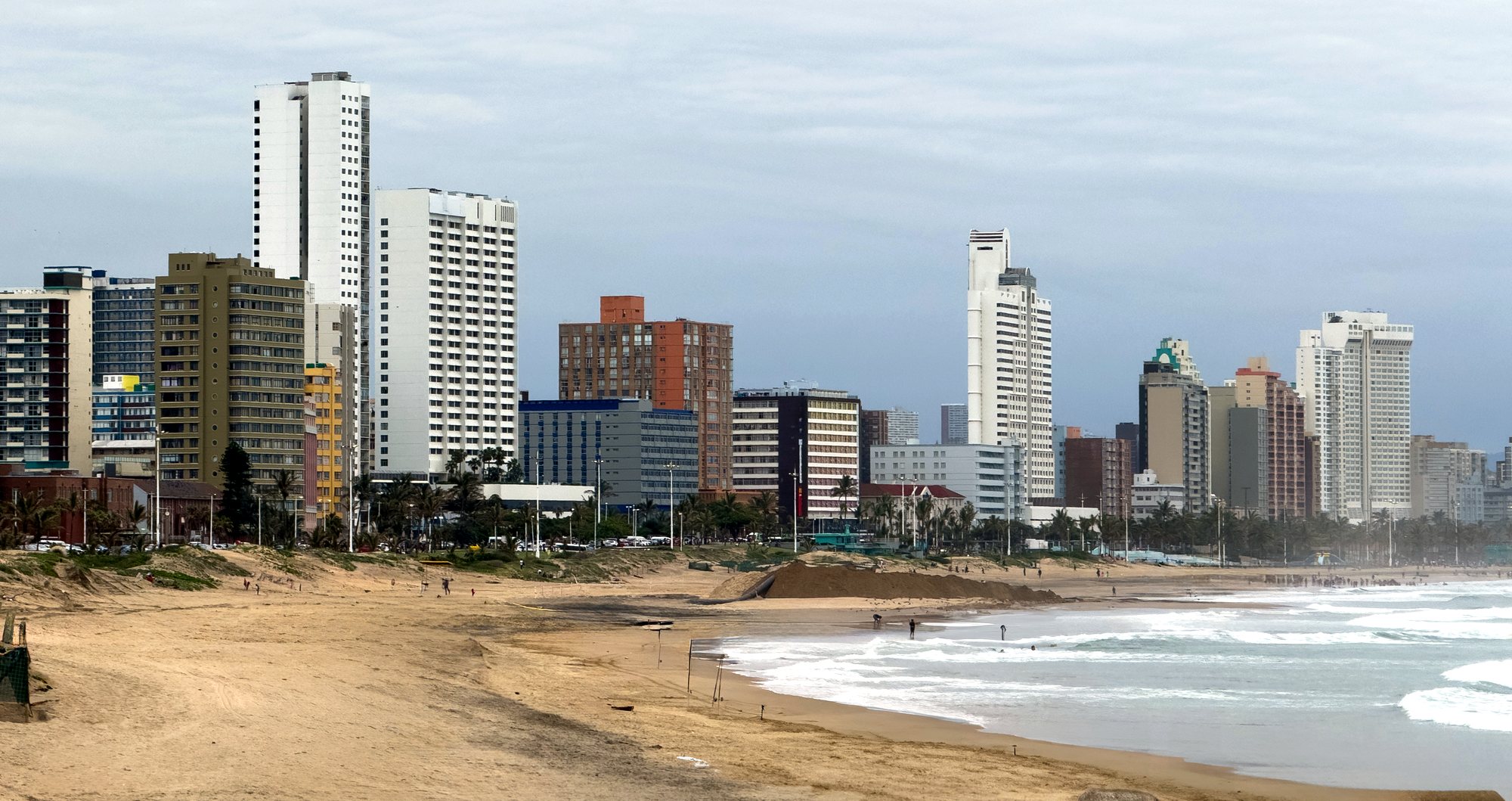 High-rise buildings along the Durban beachfront with surf breaking on the beach
