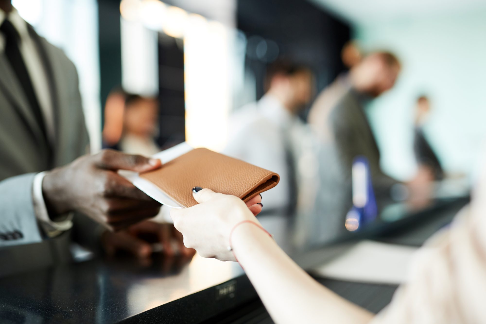 A passport holder being handed across a counter